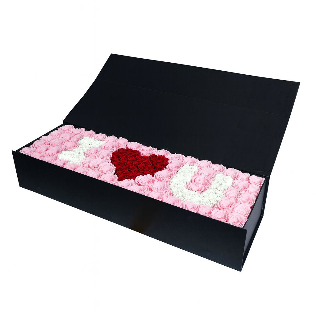 Black box with pink, white, and red heart-shaped rose arrangement on a white background