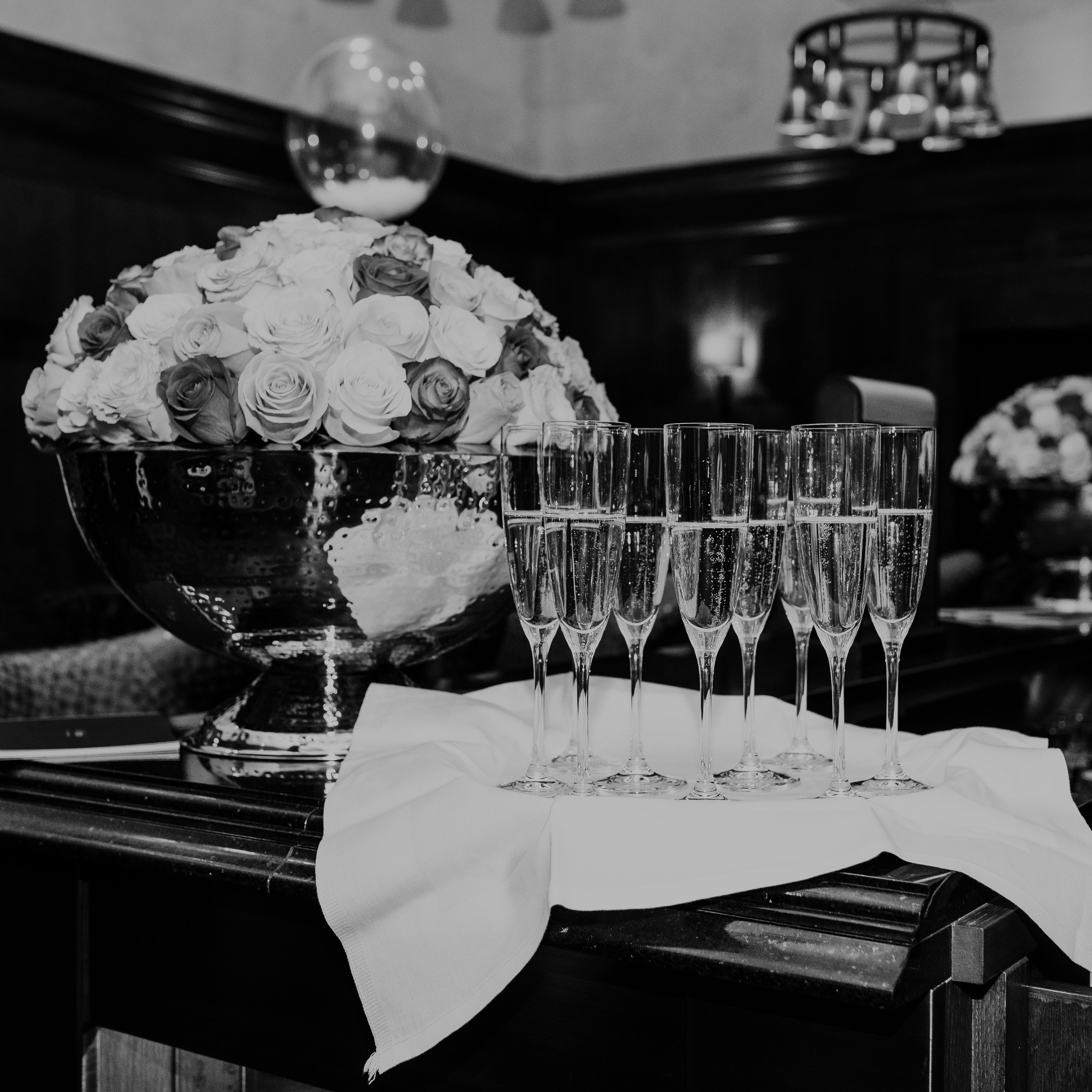 Set of champagne glasses with a floral arrangement on a table.