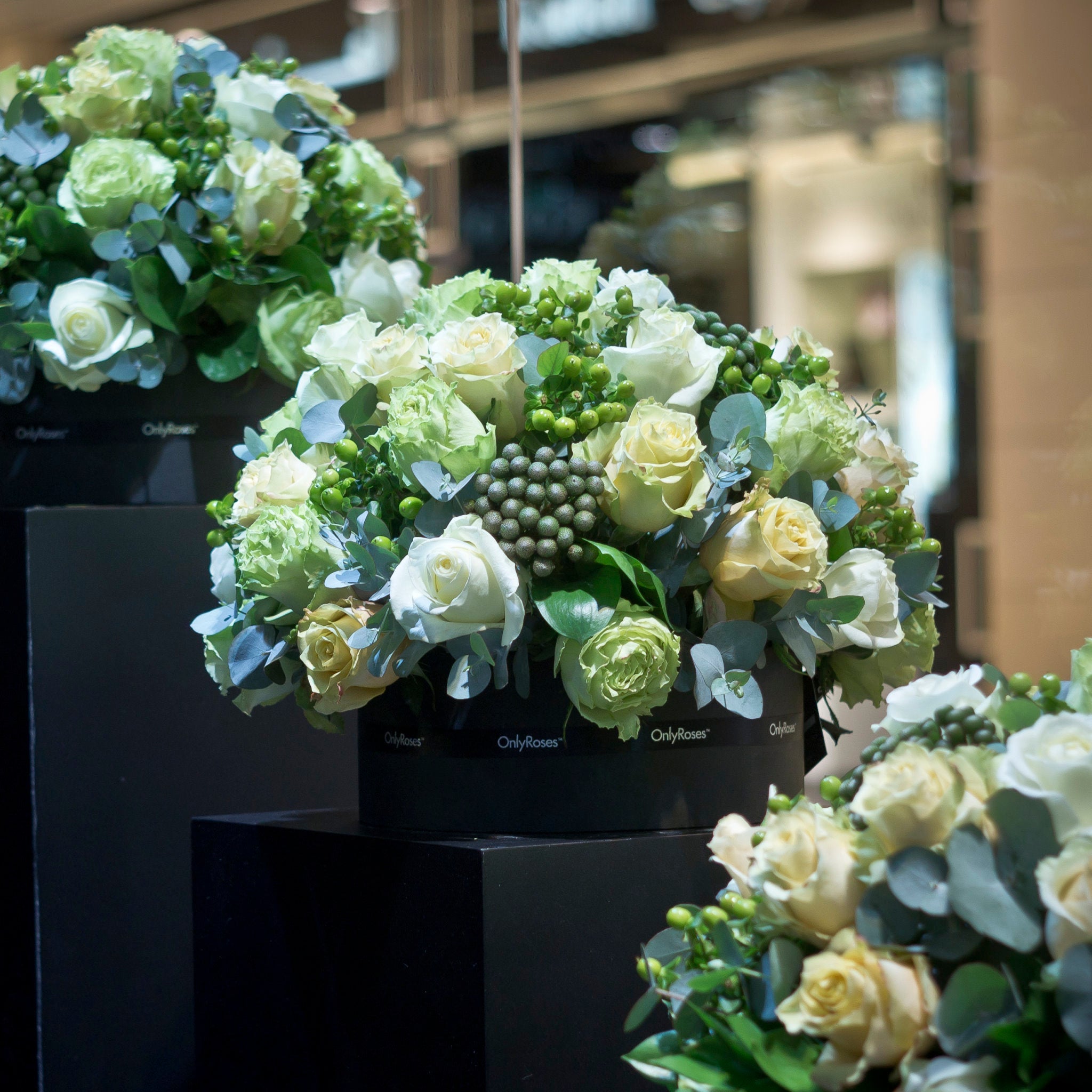 Decorative floral arrangements in black boxes with a blurred indoor background