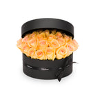 Black round box filled with yellow roses on a white background