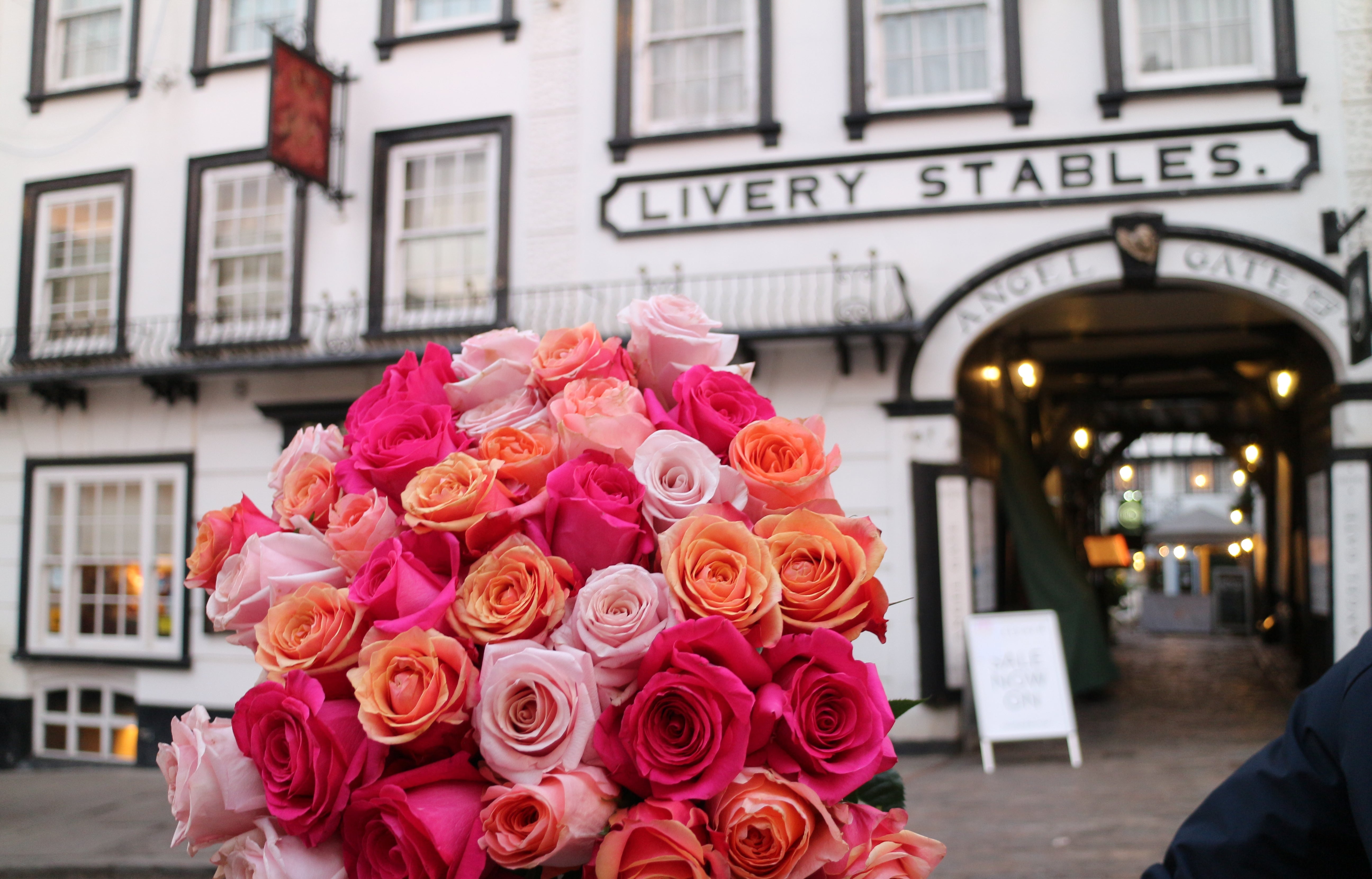 Bouquet of pink and orange roses in front of Livery Stables building