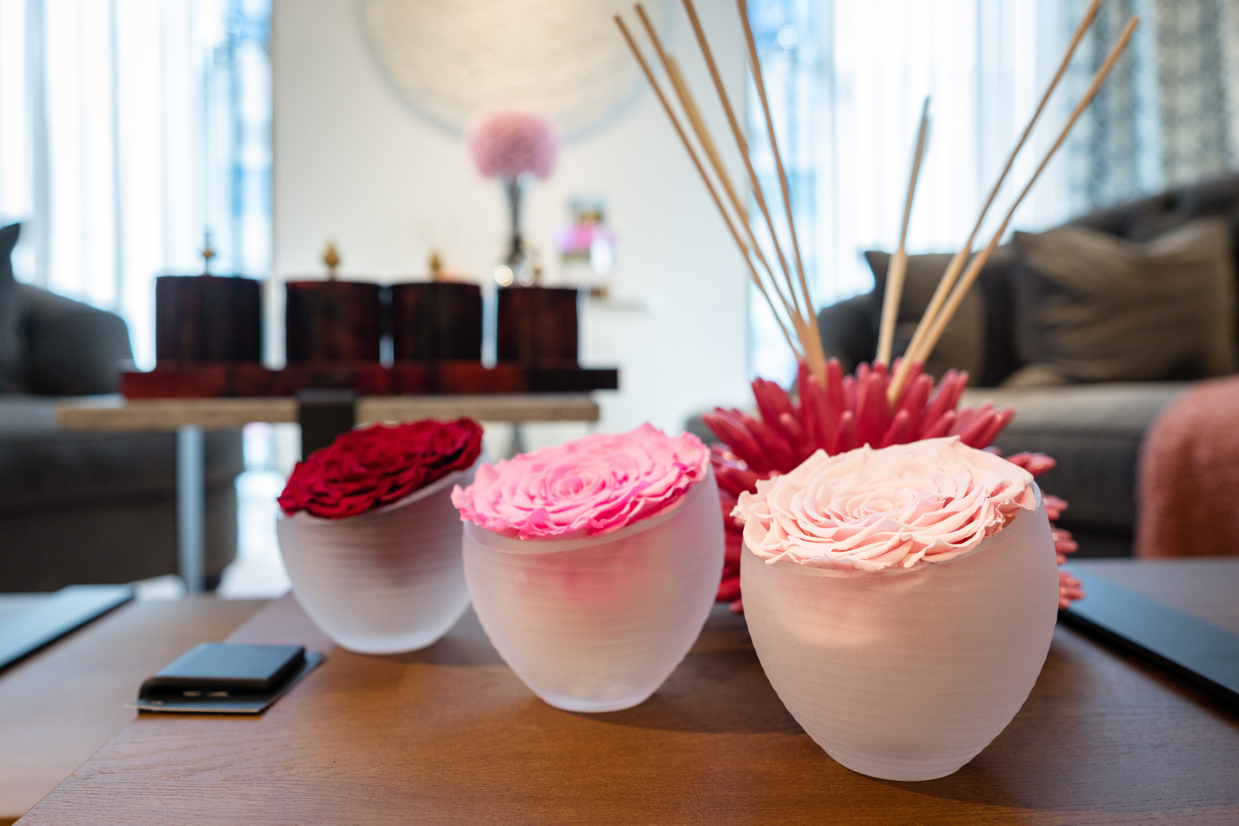 Decorative flower vases on a table with a blurred background of a living room.