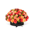 Bouquet of red, orange, and pink roses in a black box on a white background