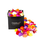 Colorful rose petals spilling out of a black 'Only Roses' box on a white background