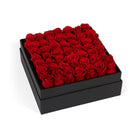 Black box filled with red roses on a white background