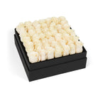 Black box filled with white roses on a white background