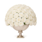 Bouquet of white roses in a decorative silver vase on a white background