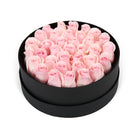 Black box filled with pink roses on a white background