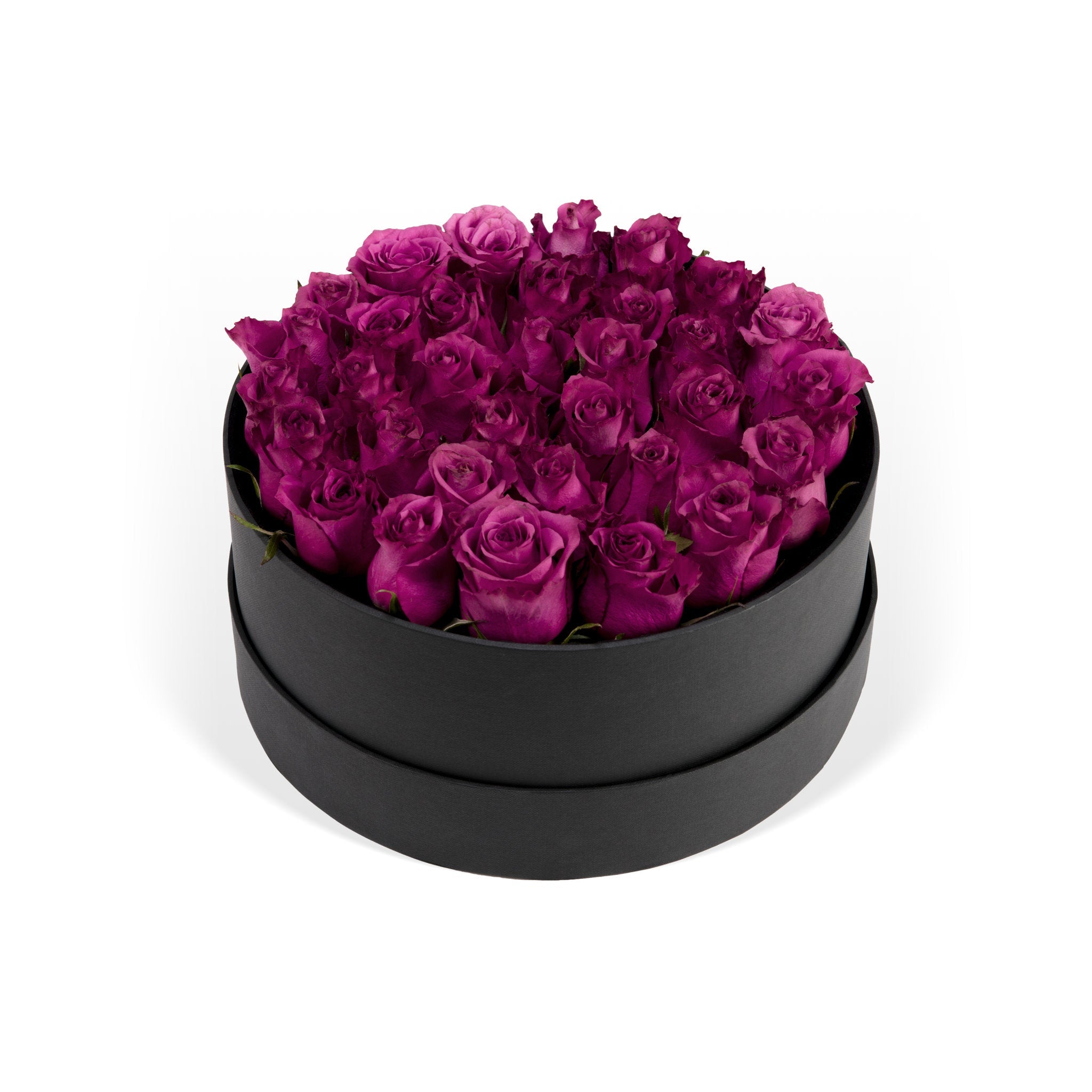 Black round box filled with purple roses on a white background