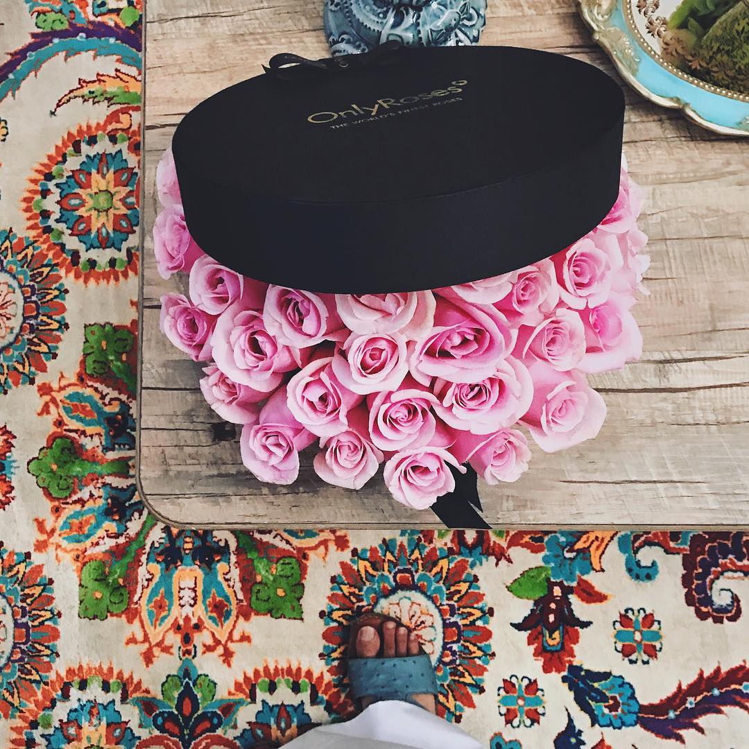 Black box with 'Only Roses' branding on a wooden surface with pink roses.