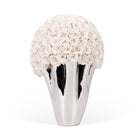 Silver vase with a spherical arrangement of white flowers on a white background