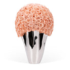 Silver vase with a large ball of peach roses on a white background