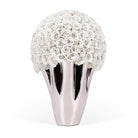 Decorative vase with white rose-like flowers and a metallic base on a white background