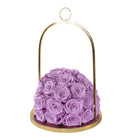 Purple roses in a gold holder on a white background