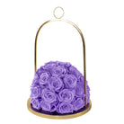 Purple roses in a gold holder on a white background
