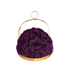 Purple roses in a gold holder on a white background
