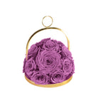 Purple roses in a gold container on a white background