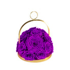 Gold hoop container with purple preserved roses on a white background