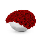 White spherical vase filled with red roses on a white background