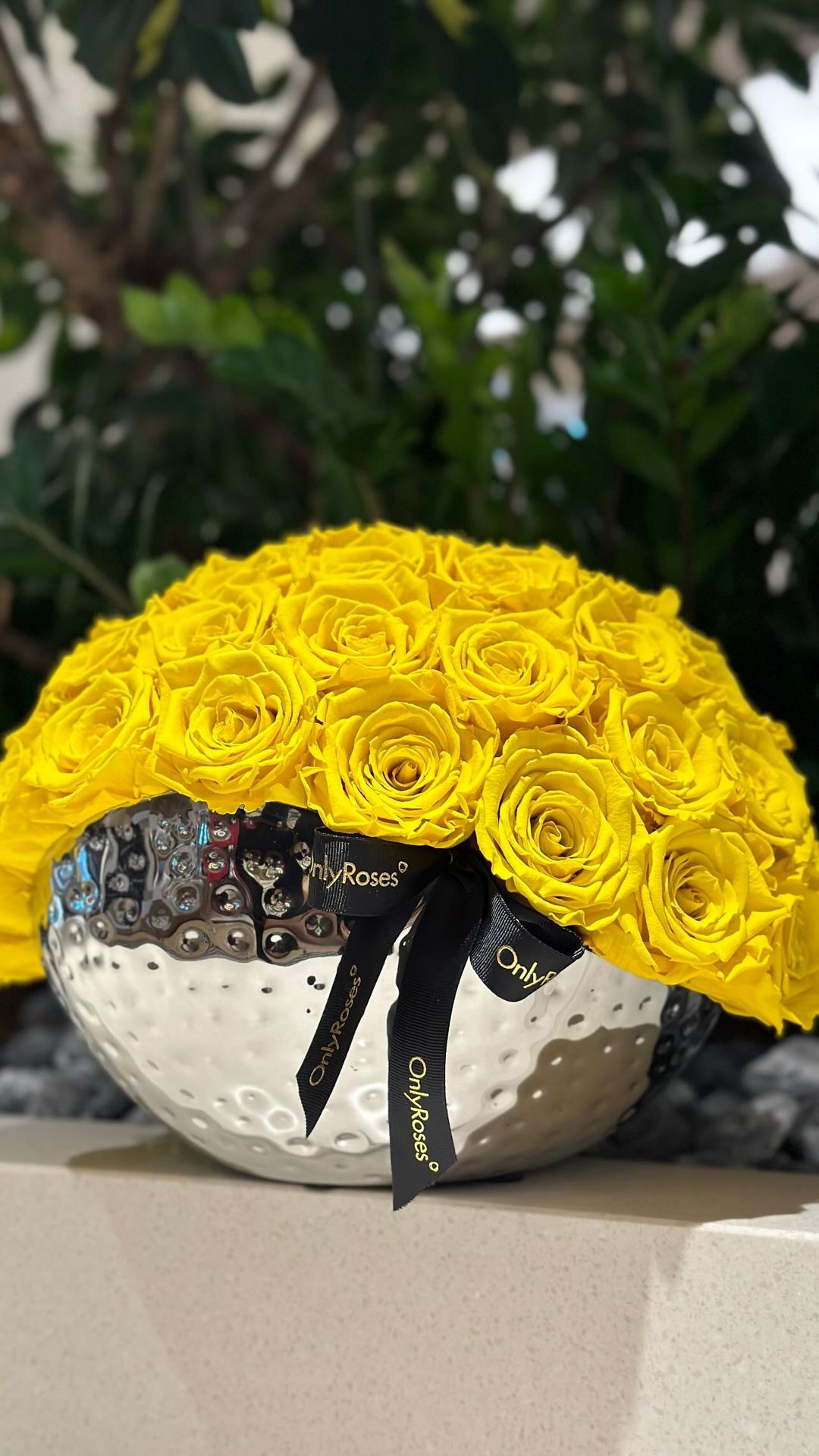 Yellow rose wreath with a silver base on a neutral background