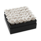 Black box filled with white roses on a white background