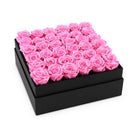 Black box filled with pink roses on a white background