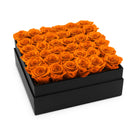Black box filled with orange roses on a white background