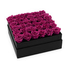 Black box filled with pink roses on a white background