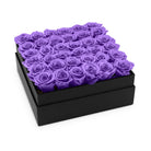 Black box filled with purple roses on a white background