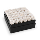 Black box filled with white roses on a white background