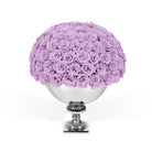 Bouquet of purple roses in a silver vase on a white background