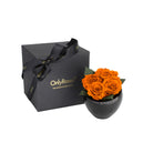 Black gift box with 'Only Roses' branding next to a black vase with orange roses on a white background