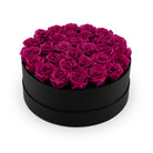 Black box filled with pink roses on a white background