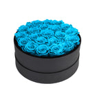 Black round box filled with blue roses on a white background