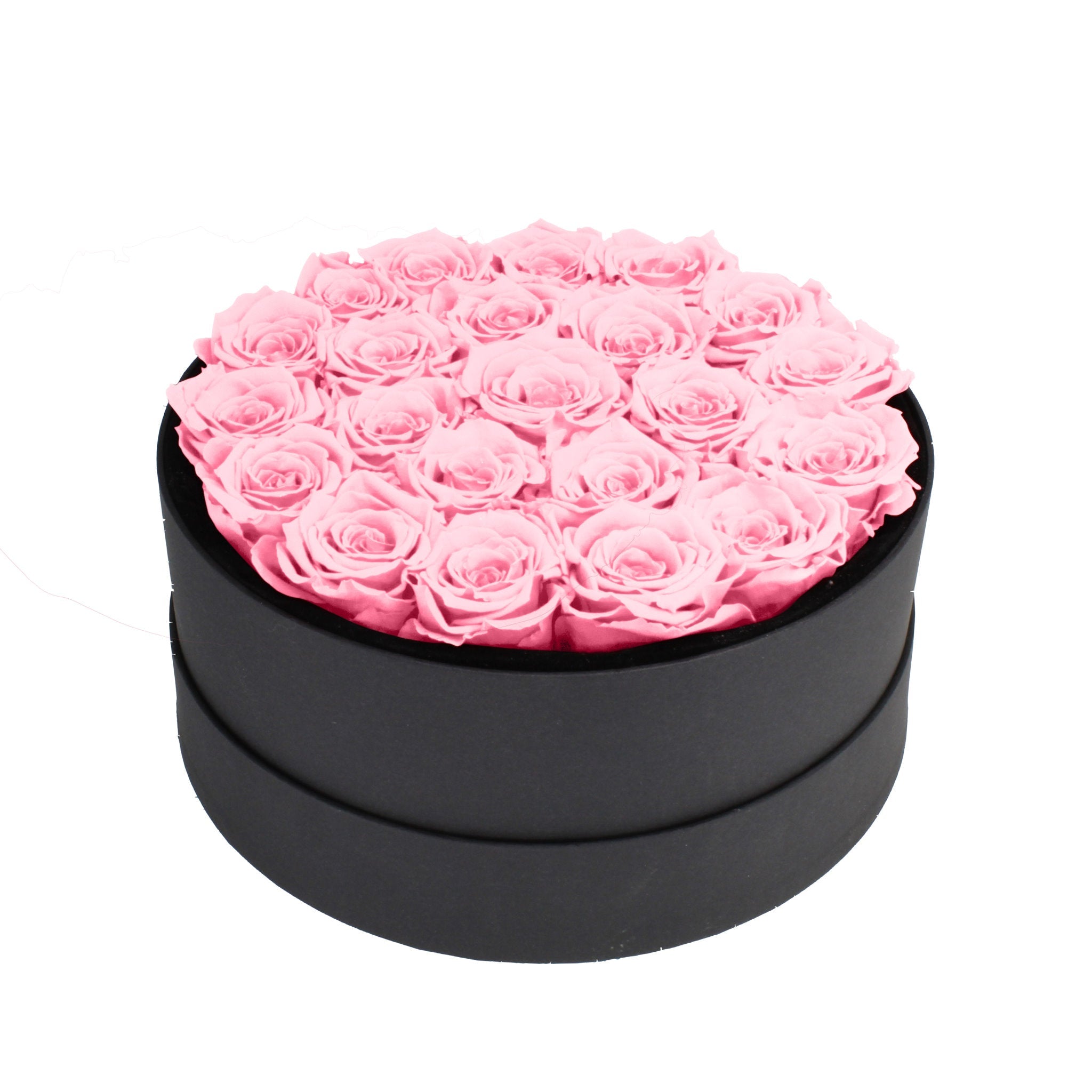 Black round box filled with pink roses on a white background
