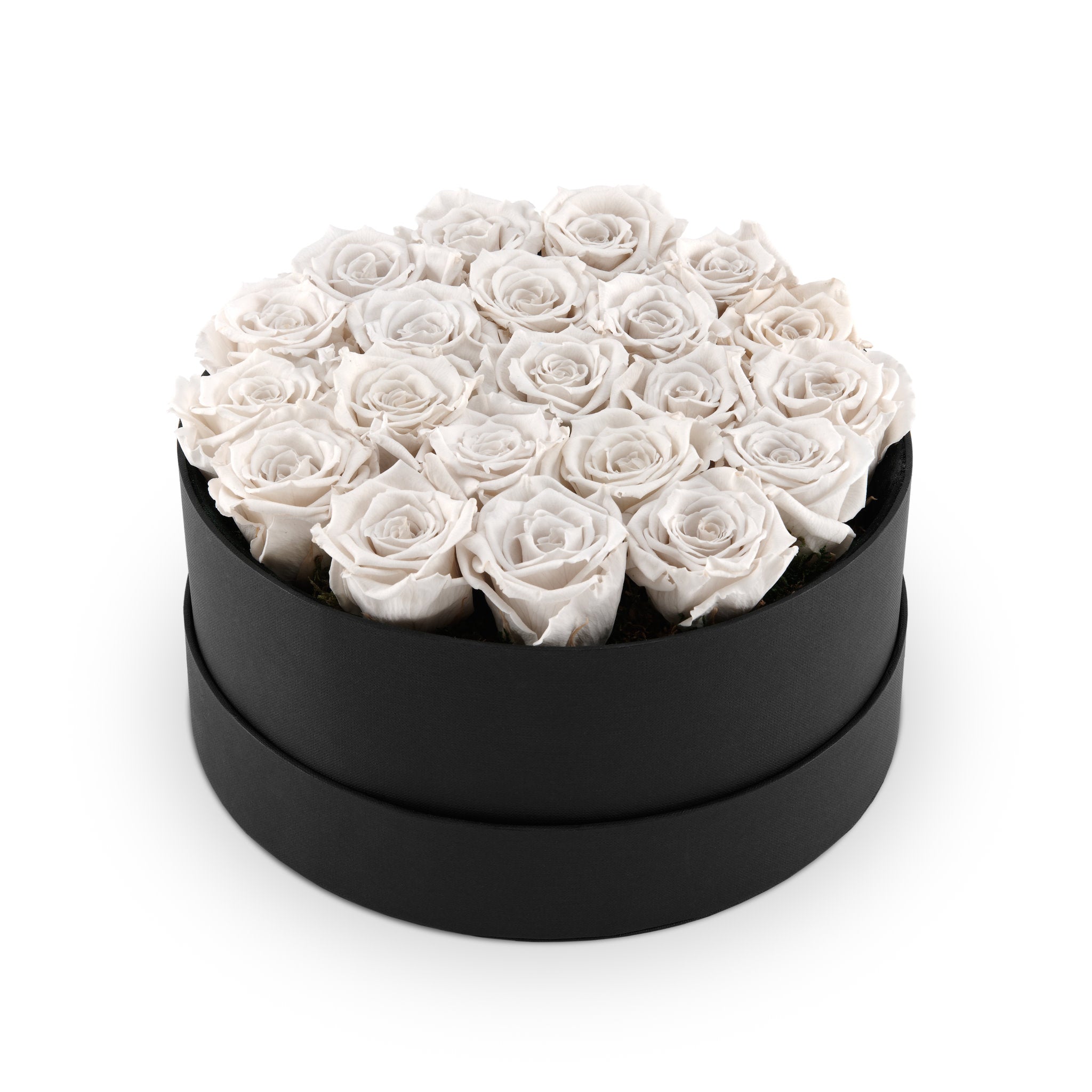 Black round box filled with white roses on a white background