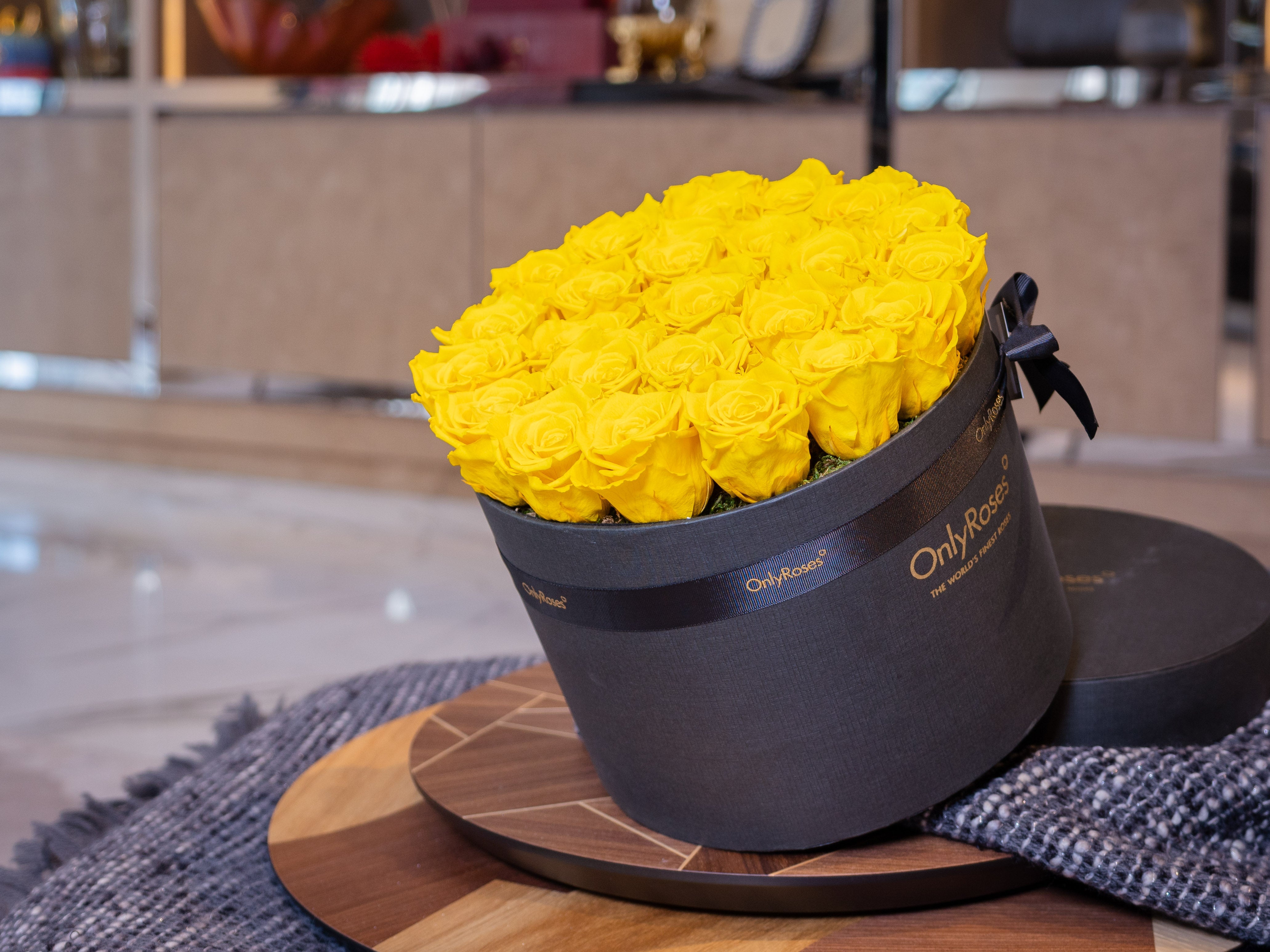 Black box with yellow roses on a wooden table