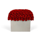 Rectangular box filled with red roses on a white background
