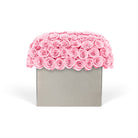 Pink rose arrangement in a gray box on a white background