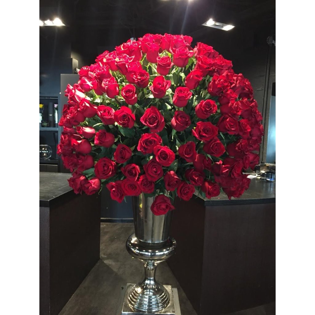 Large bouquet of red roses in a silver vase on a dark background