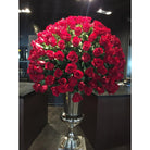 Large bouquet of red roses in a silver vase on a dark background