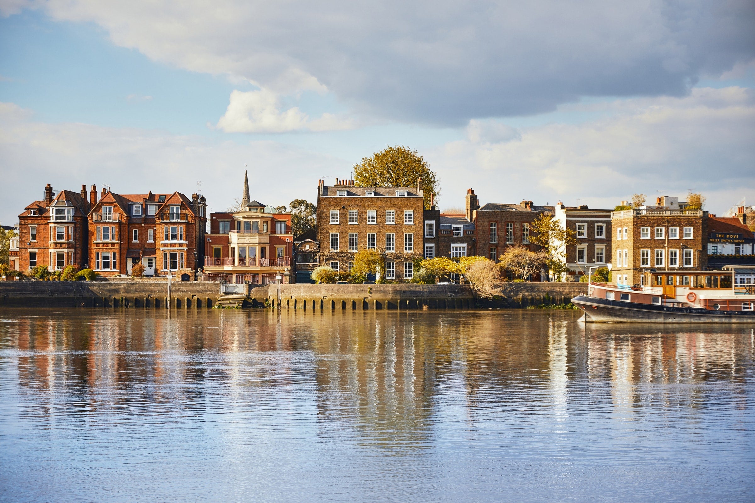 Row of houses along a waterfront with a clear sky.
