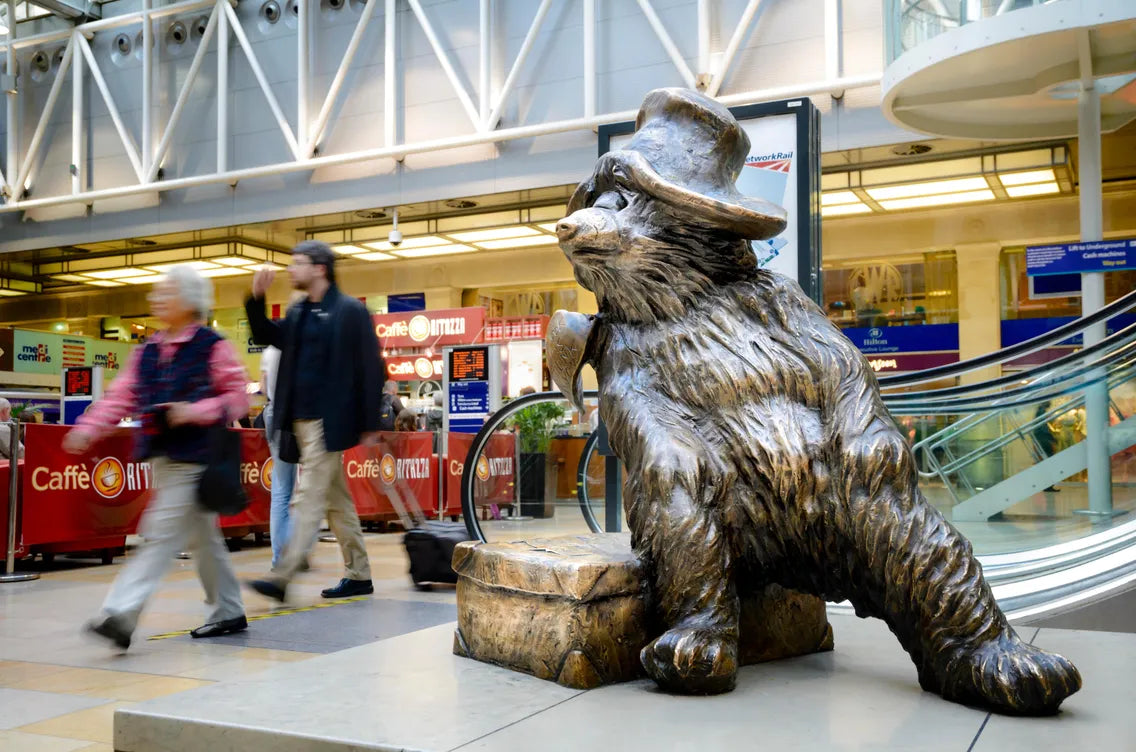 Bronze bear statue with a top hat in a shopping mall setting