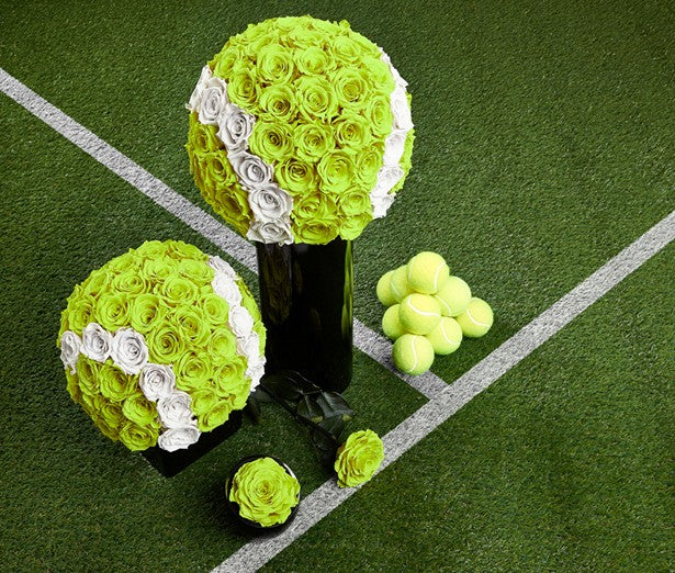 Two flower arrangements shaped like tennis balls on a tennis court